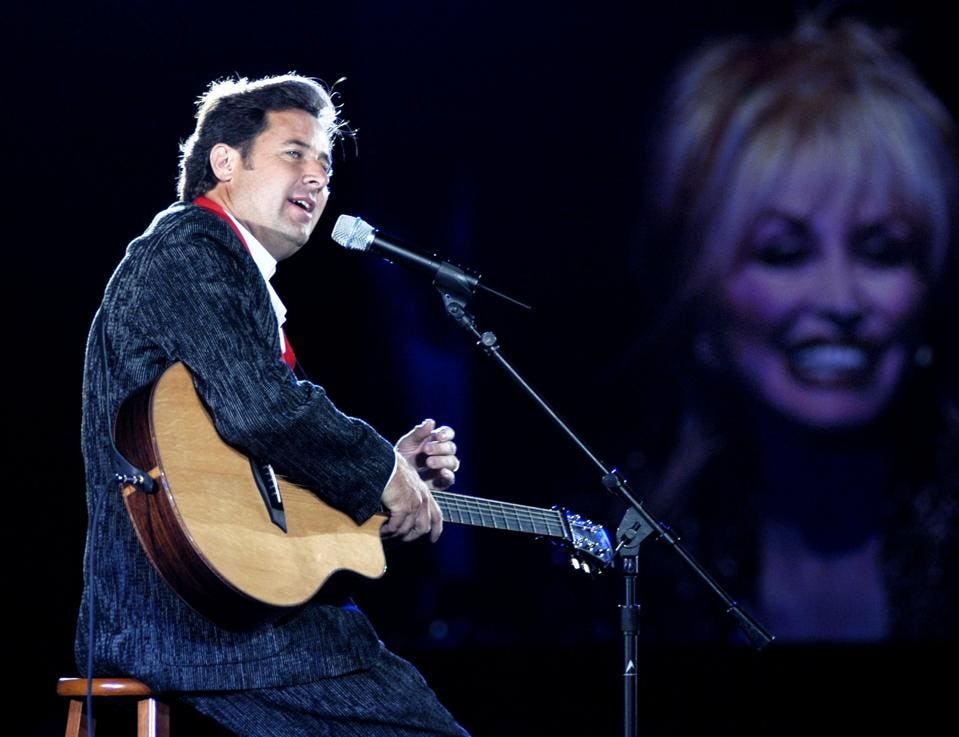 Vince Gill performs while Dolly Parton looks on during 2003 BMI Country Music Awards at BMI Nashville.